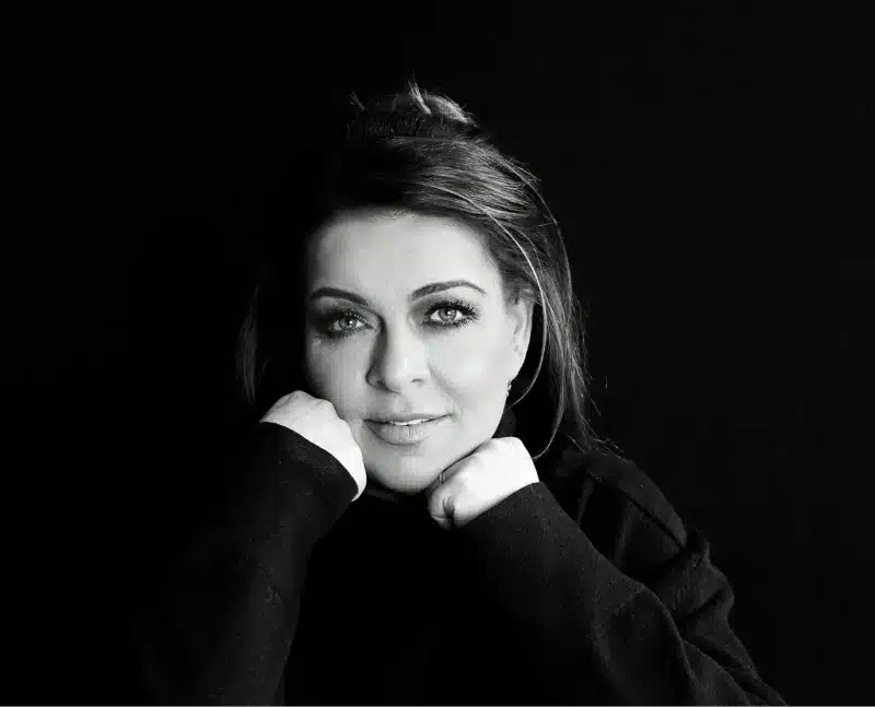 Svetlana B. lächelt mit aufgestütztem Kopf in die Kamera